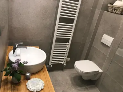 a bathroom with a white sink and a toilet at Street Flat in Ljubljana