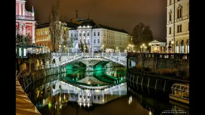 a bridge over a river in a city at night at Street Flat in Ljubljana