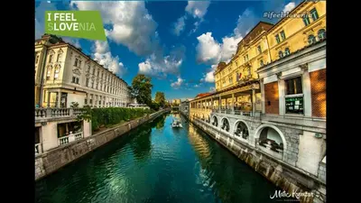 a view of a river with buildings and a bridge at Street Flat in Ljubljana