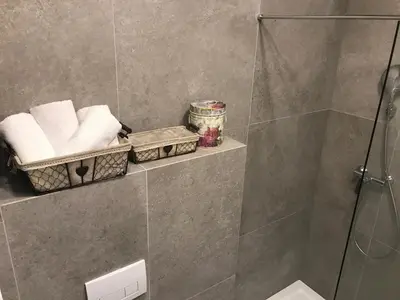 a bathroom with a shower and a toilet and towels at Street Flat in Ljubljana