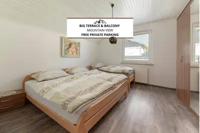 a bed in a bedroom with a sign above it at Apartmaji Seljak in Preddvor