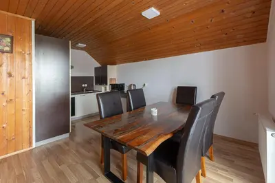 a dining room with a wooden table and black chairs at Apartmaji Seljak in Preddvor