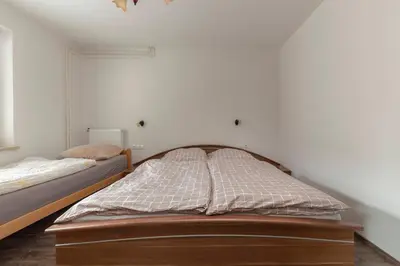 a bedroom with a bed and a white wall at Apartmaji Seljak in Preddvor