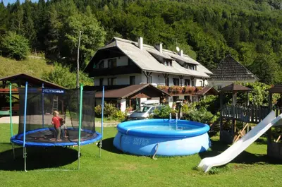 a person standing on a slide and a playground at Apartmaji Rabič in Bohinj