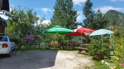 a group of umbrellas and benches in a yard at Farm stay Majdač in Solčava