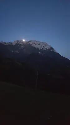 a mountain with the moon on top of it at Farm stay Majdač in Solčava