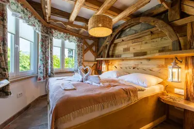 a bedroom with a large bed in a room with wooden ceilings at Central Bled House in Bled