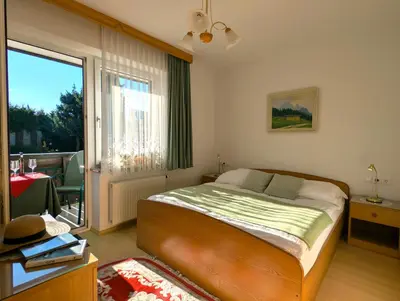 a bedroom with a bed and a large window at Garden Apartments Janša in Radovljica