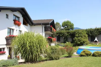 a house with a yard with a pool in front of it at Garden Apartments Janša in Radovljica
