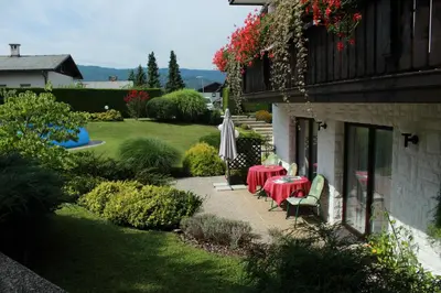 a patio with a table and chairs and an umbrella at Garden Apartments Janša in Radovljica