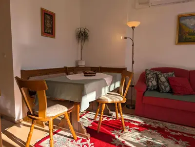 a living room with a table and chairs and a couch at Garden Apartments Janša in Radovljica