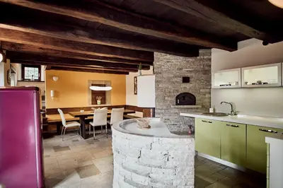 a kitchen and dining room with a dining table at Tmbin's barn - nature, horses, family in Sežana