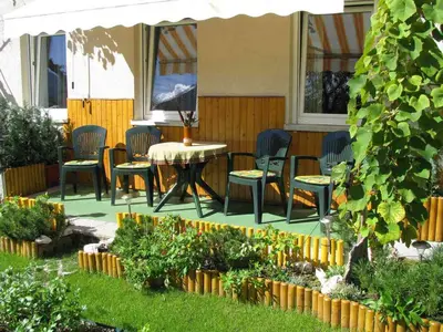 a patio with chairs and a table in a yard at Apartment Nevela in Bovec
