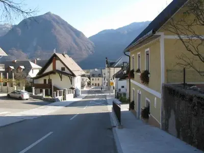 a street in a town with a mountain in the background at Apartment Nevela in Bovec