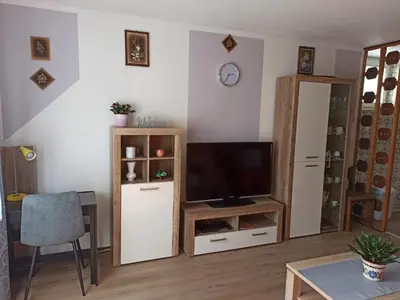 a living room with a television and a table at Apartment Nevela in Bovec