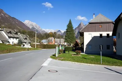 an empty street in a small town with mountains at Apartment Mavrica in Bovec