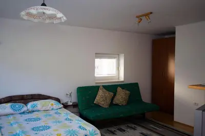 a bedroom with a bed and a green couch at Apartment Mavrica in Bovec