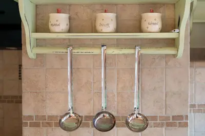 four spoons are hanging on a shelf in a kitchen at Homestead farm Tešnak in Gorenja Vas