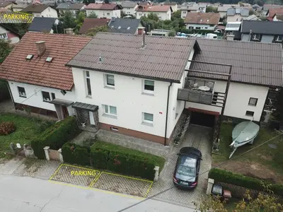 a white house with a car parked in front of it at Apartment Milena in Maribor