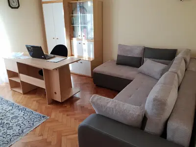 a living room with a couch and a desk with a laptop at Apartment Milena in Maribor