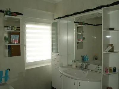 a white bathroom with a sink and a window at Apartment Milena in Maribor