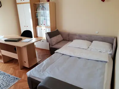 a bedroom with a bed and a desk with a laptop at Apartment Milena in Maribor