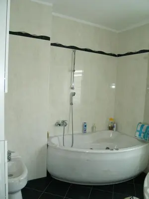 a white bathroom with a tub and a toilet at Apartment Milena in Maribor