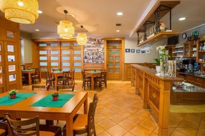 a restaurant with wooden tables and chairs and a counter at Guesthouse Beno in Starše
