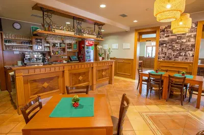 a restaurant with wooden tables and chairs and a bar at Guesthouse Beno in Starše