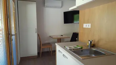 a small kitchen with a sink and a table at Glamping SUN VALLEY Bioterme in Mala Nedelja