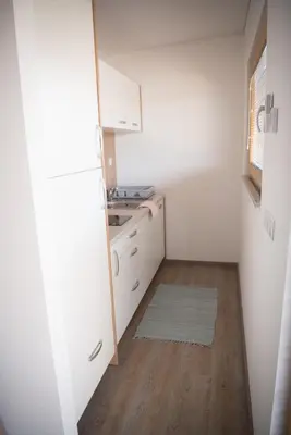 a small kitchen with white cabinets and a sink at Glamping SUN VALLEY Bioterme in Mala Nedelja