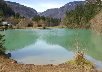 a large emerald green lake with mountains in the background at Apartma Manca in Kranjska Gora