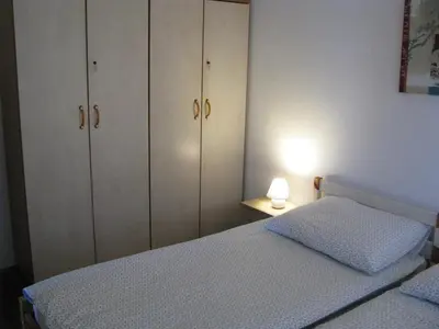 a bedroom with white cabinets and a bed and a lamp at Hiša marjetica in Maribor