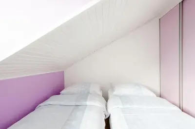 two beds in a room with purple and white walls at Green Point in Preserje