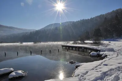 a lake covered in snow with the sun in the background at Green Point in Preserje
