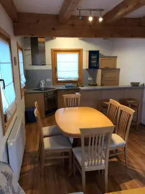 a kitchen and dining room with a table and chairs at Apartmaji Zlata Lisička in Cerkno