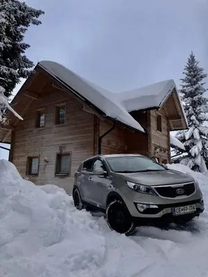 a car parked in the snow in front of a house at Apartmaji Zlata Lisička in Cerkno