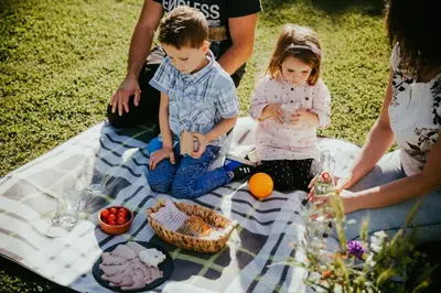 a group of people sitting on a picnic blanket at RANČ JUREŠ in Ljutomer