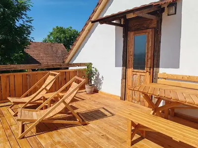 a wooden deck with two chairs and a wooden door at RANČ JUREŠ in Ljutomer