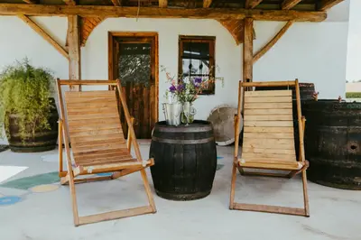two wooden chairs sitting next to a barrel at RANČ JUREŠ in Ljutomer