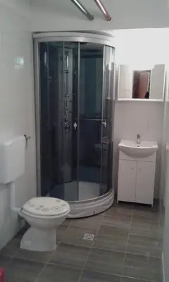 a bathroom with a shower and a toilet and a sink at Emona Apartments in Ljubljana