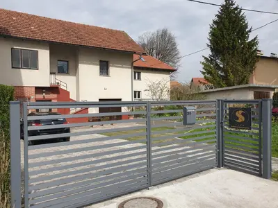 a gate with a sign on it in front of a house at Sašo Rooms & Apartments in Ljubljana