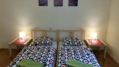 a bedroom with two beds and two lamps on tables at Sašo Rooms & Apartments in Ljubljana