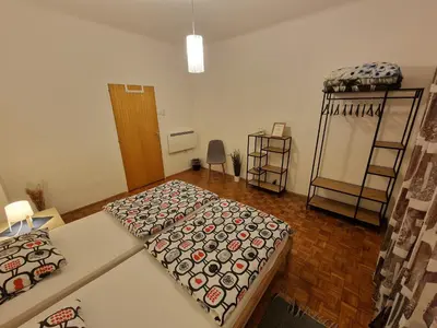a small room with two beds and a table at Sašo Rooms & Apartments in Ljubljana
