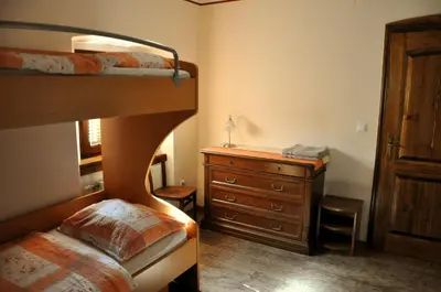 a bedroom with two bunk beds and a dresser at Bed & Breakfast Pr'Sknet in Šenčur