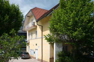 a yellow building with a car parked in front of it at Apartment Emona Bled 4 in Bled