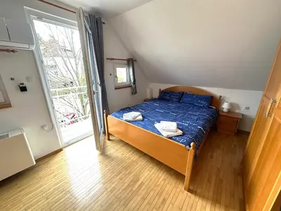a bedroom with a bed and a large window at Apartment Emona Bled 4 in Bled