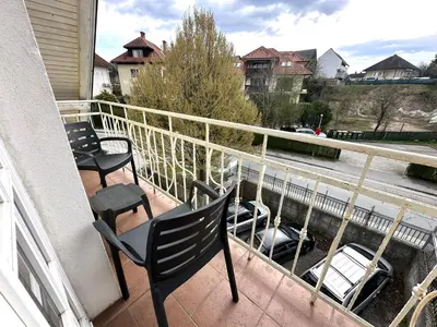 a balcony with chairs and a car on a street at Apartment Emona Bled 4 in Bled