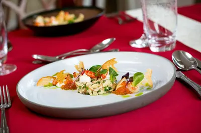 a white plate of food on a red table at Rimske Terme Resort - Hotel Zdraviliški dvor in Rimske Toplice