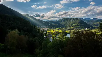 a valley in the mountains with a town and a river at Rimske Terme Resort - Hotel Zdraviliški dvor in Rimske Toplice